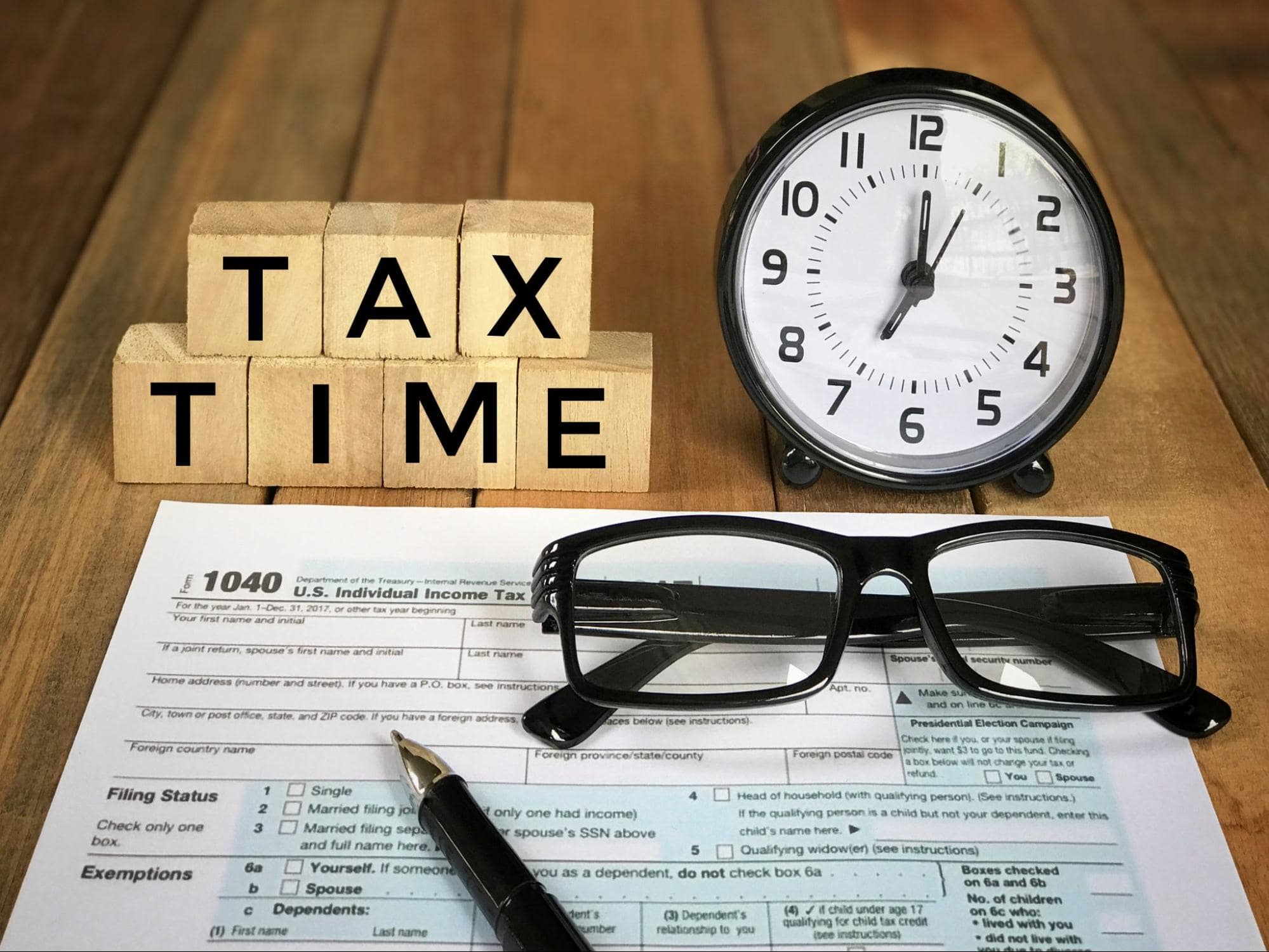 Income Tax Paperwork with Glasses and Clock